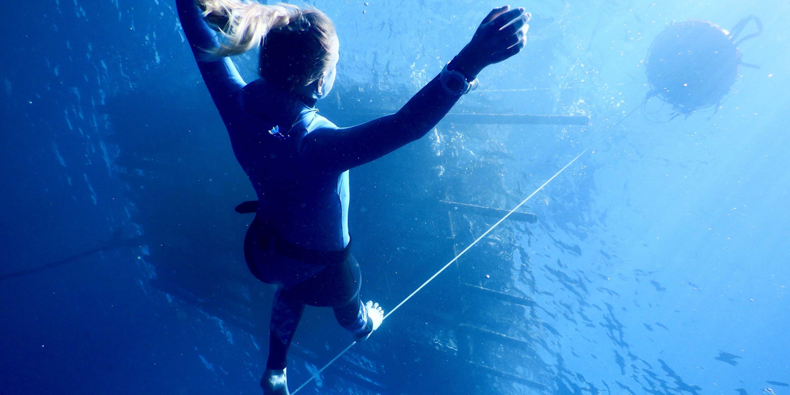 sous l'eau, marcher sur un fil, en équilibre sur un fil, bras levés pour s'équilibrer